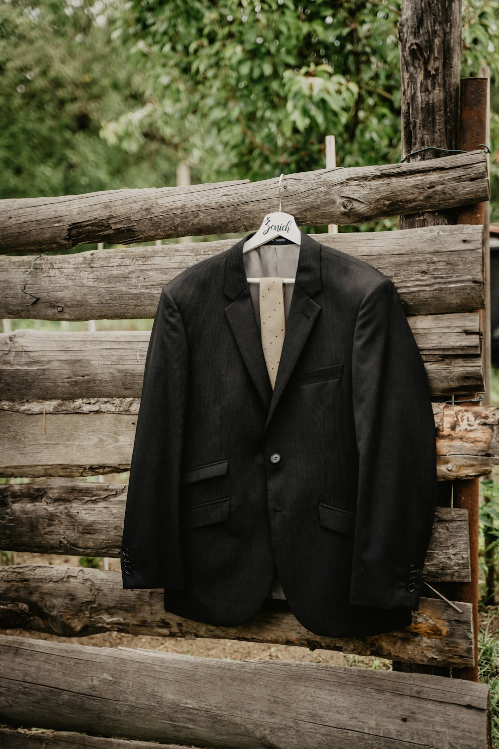 chaqueta de traje negra sobre percha de plástico blanco