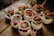 A colorful assortment of flan jars arranged on a rustic wooden table.