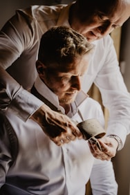 man in white dress shirt holding black ceramic mug