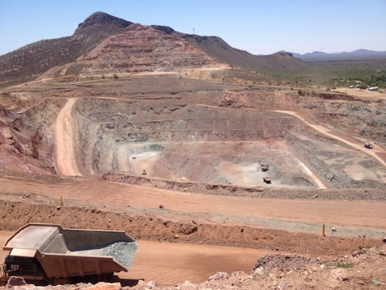 A panoramic view of a mining site with silica deposits under clear blue skies.