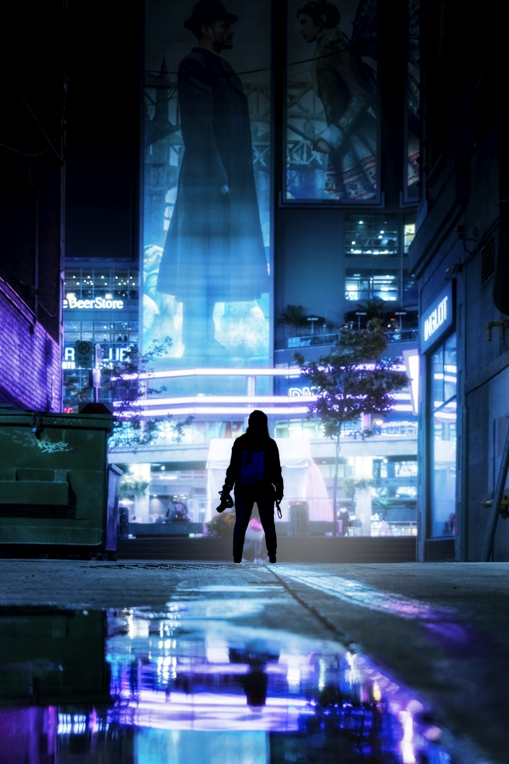 woman in black coat walking on sidewalk during night time
