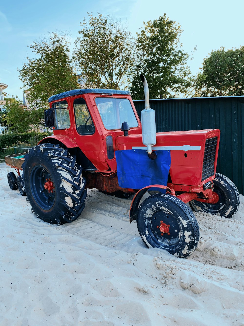 red tractor on snow covered ground during daytime