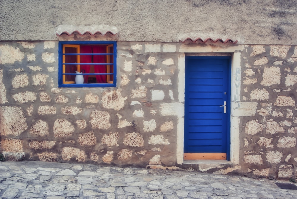 blue wooden door on brown brick wall