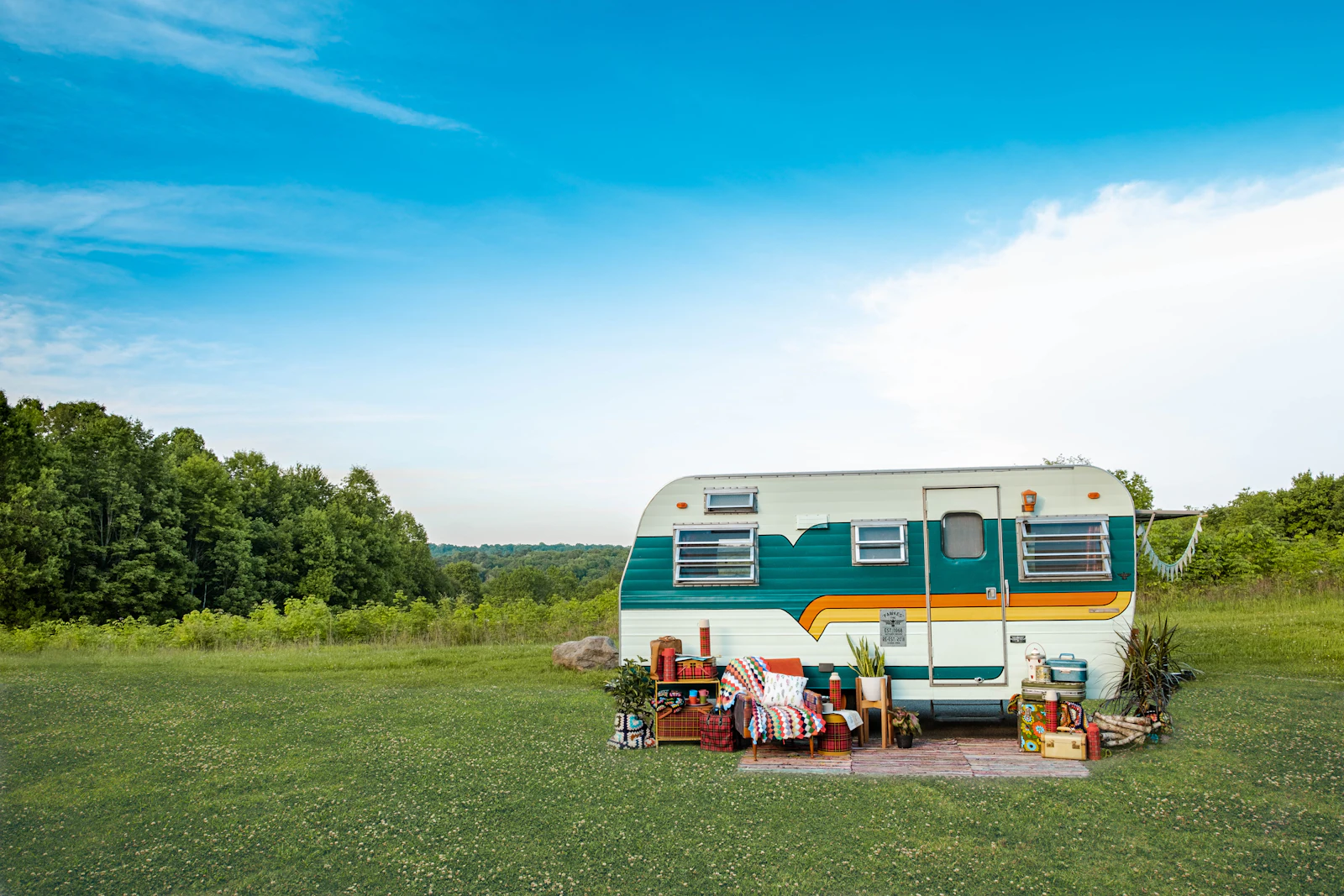 A white caravan trailer parked on grass under a blue sky