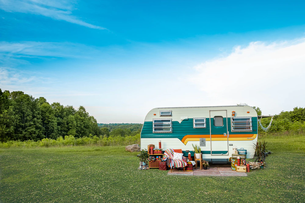 A retro camper trailer parked in a green field
