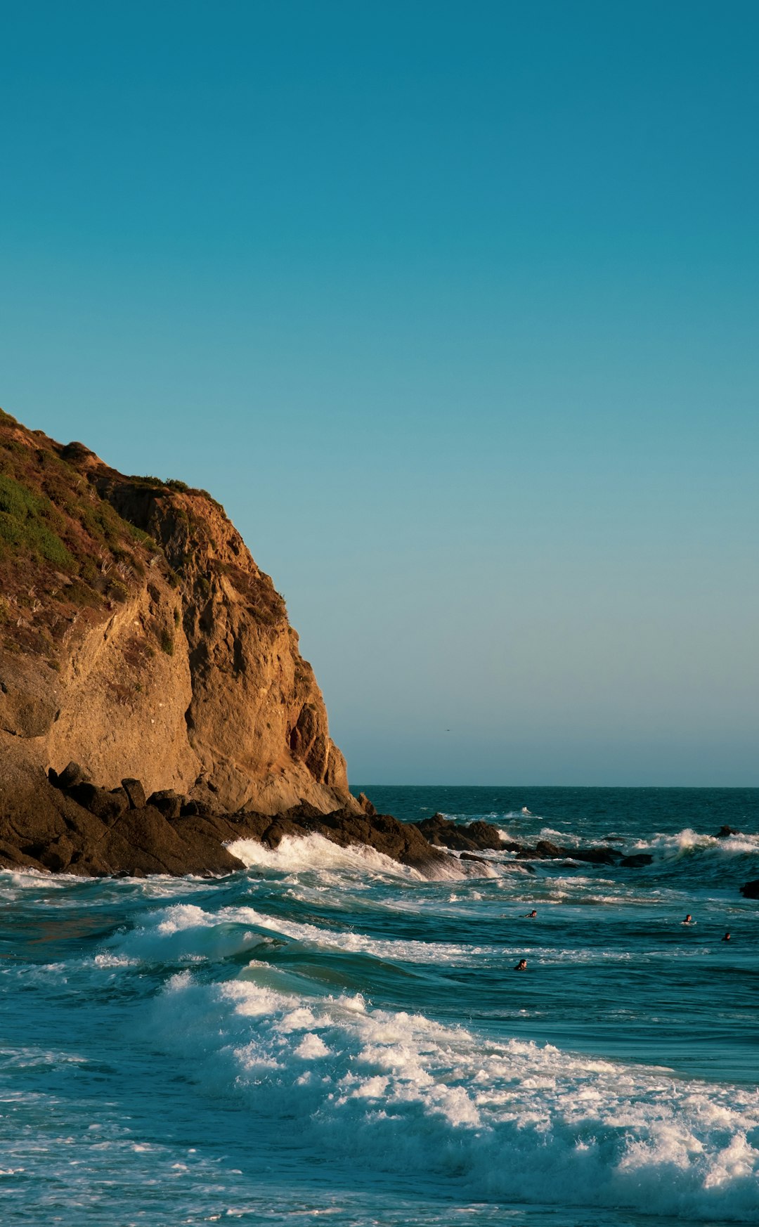 brown rock formation beside sea during daytime