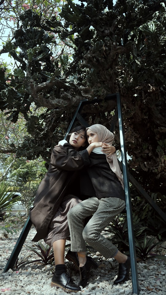 woman in black jacket sitting on swing chair in Kebun Raya Bogor Indonesia