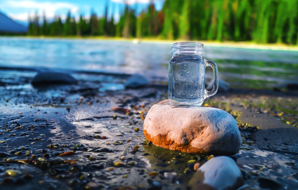 clear glass jar on brown rock