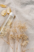 A clear water bottle filled with fresh lemon slices and water, placed on a sunny windowsill.