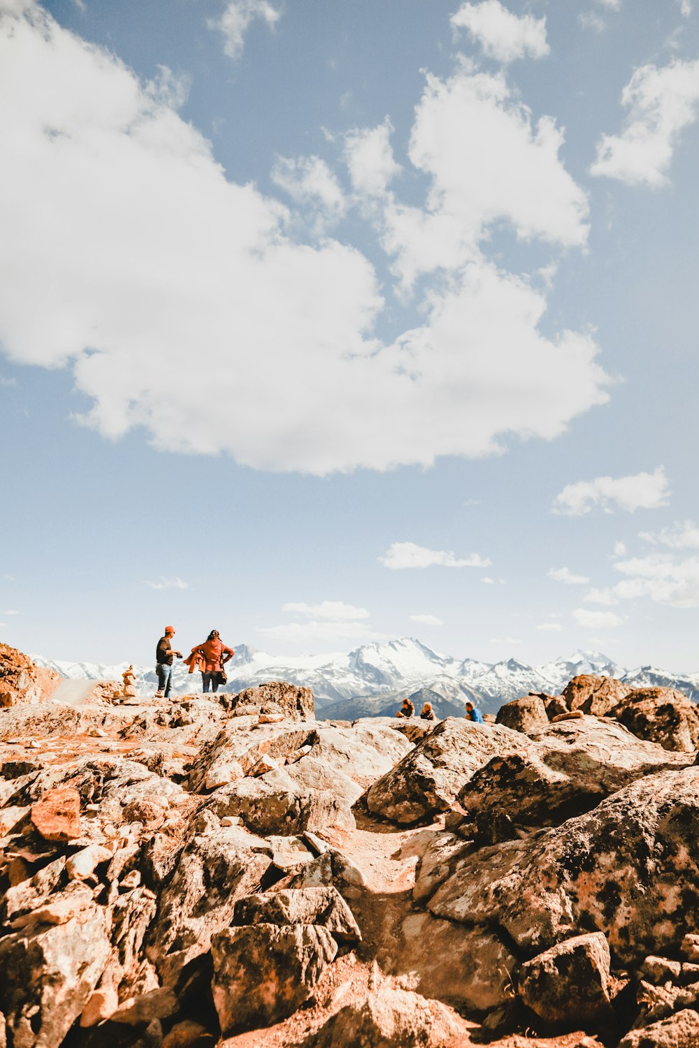 people on rocky hill under blue sky during daytime