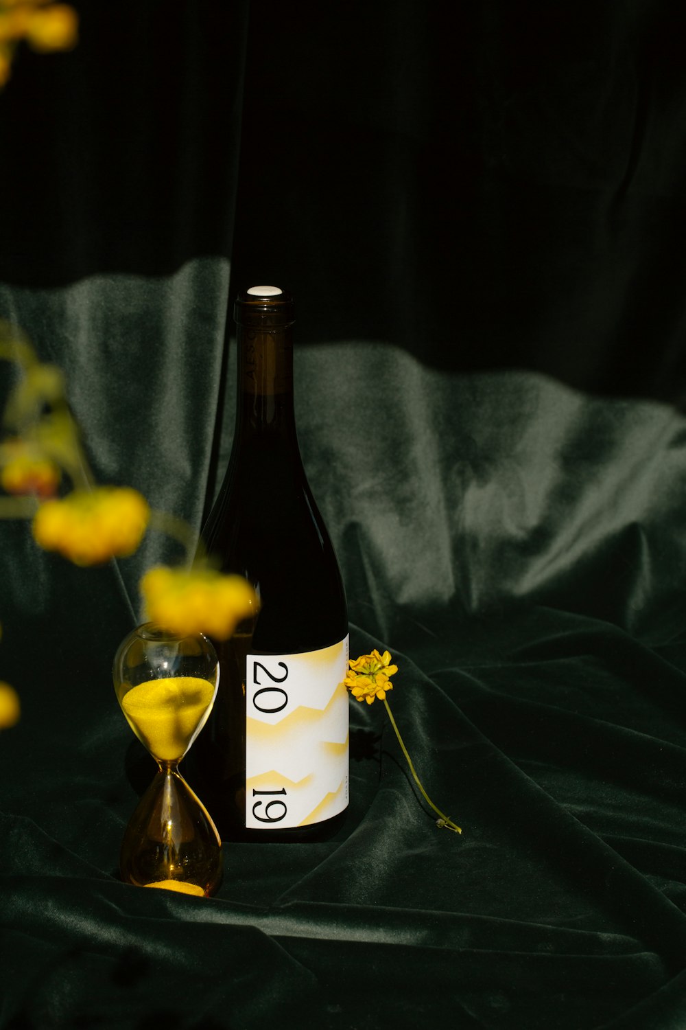 white labeled bottle beside clear wine glass