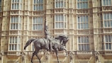 black horse statue in front of brown concrete building during daytime