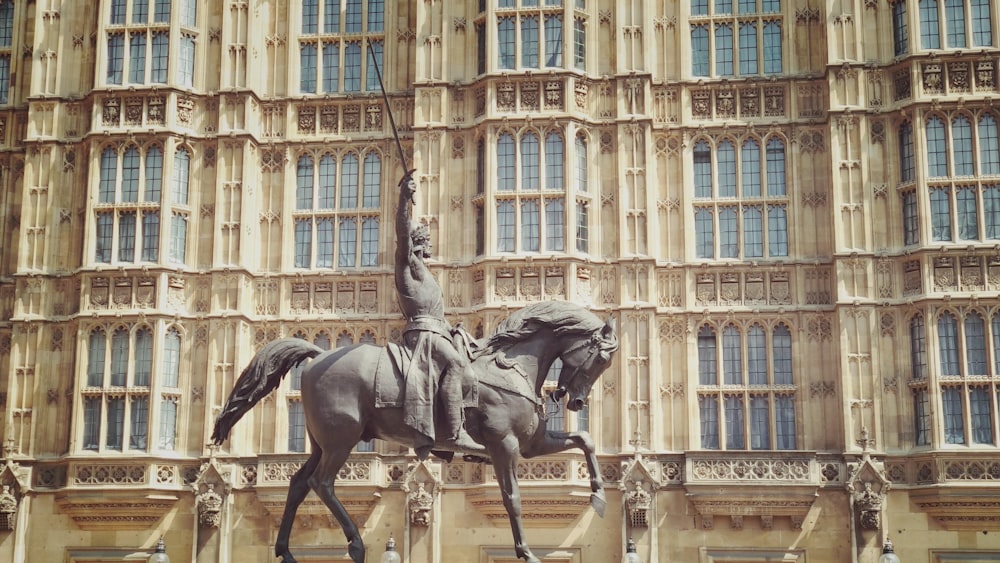 black horse statue in front of brown concrete building during daytime