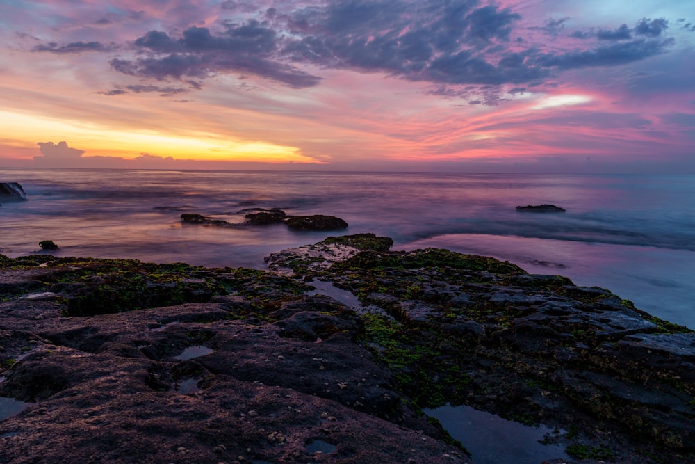 body of water under cloudy sky during sunset