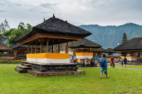people standing near brown and white house during daytime in Ulun Danu Beratan Temple Indonesia