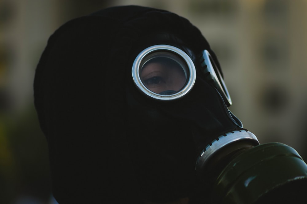 person wearing black gas mask