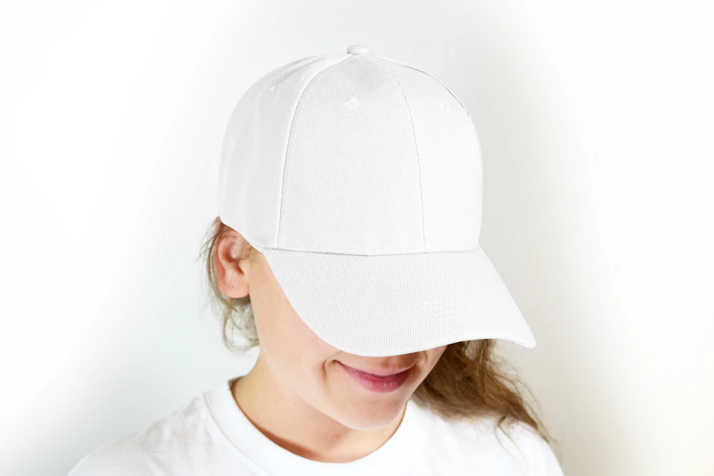 White cotton baseball cap worn low over the eyes