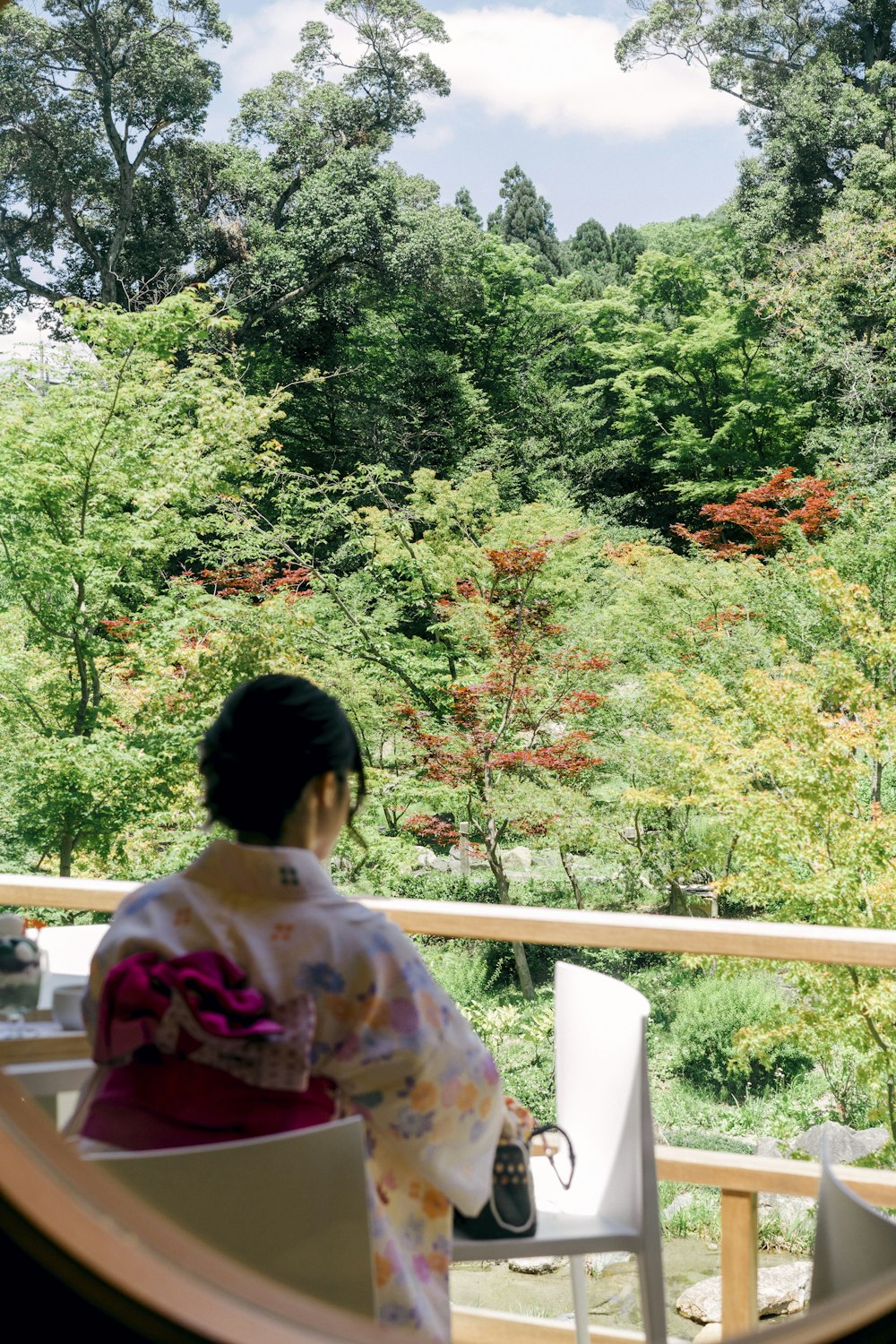 woman in white and pink floral shirt sitting on white bench