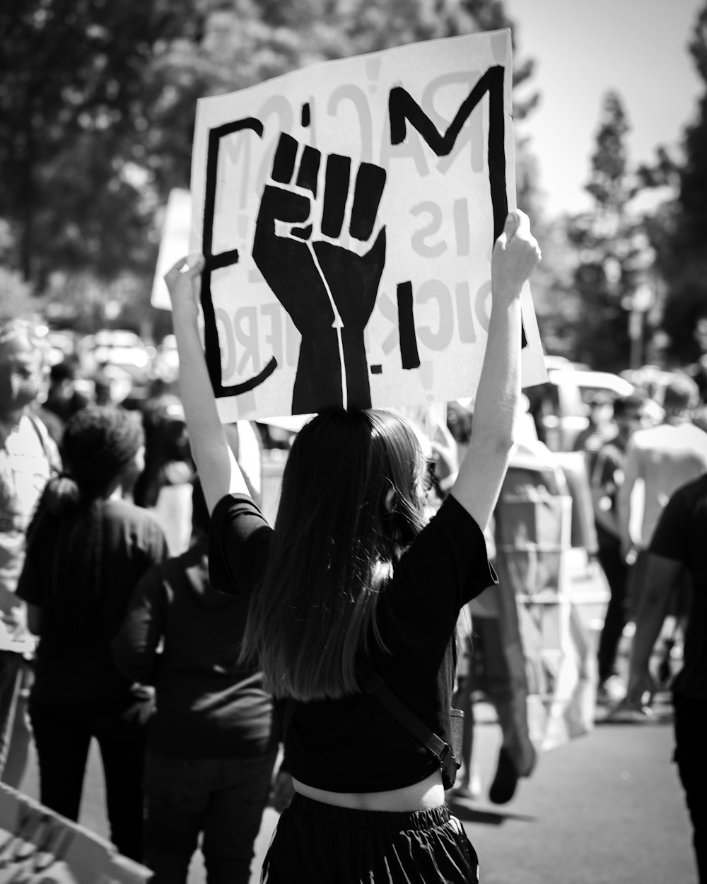 grayscale photo of woman holding peace sign