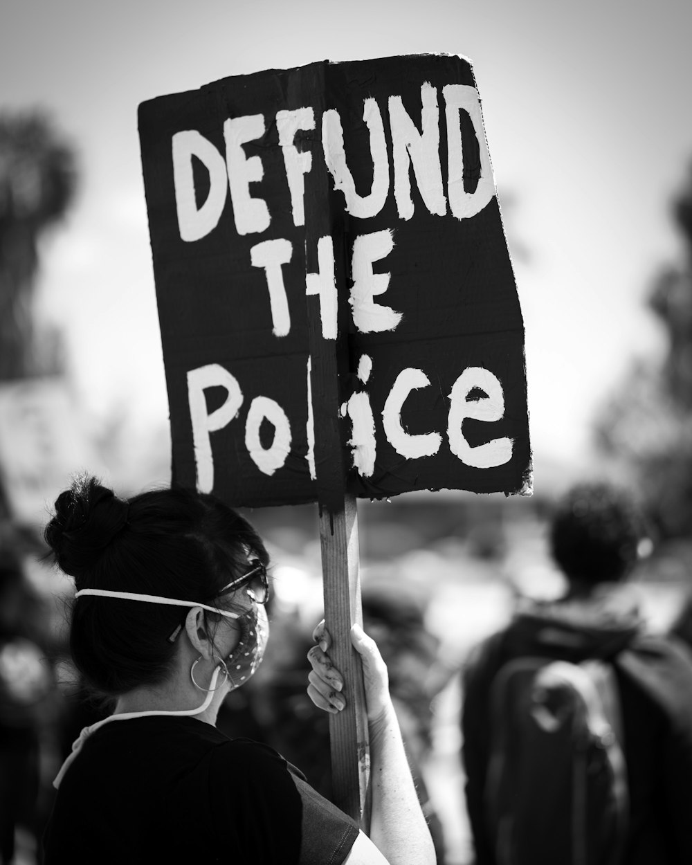 grayscale photo of woman holding happy birthday signage