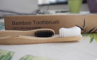 two bamboo toothbrushes sitting on a table.