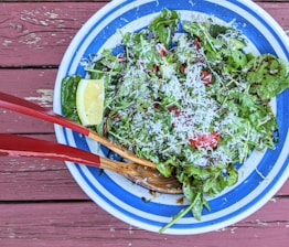 A vibrant plate of fresh salad with mixed greens, cherry tomatoes, and lemon wedges.