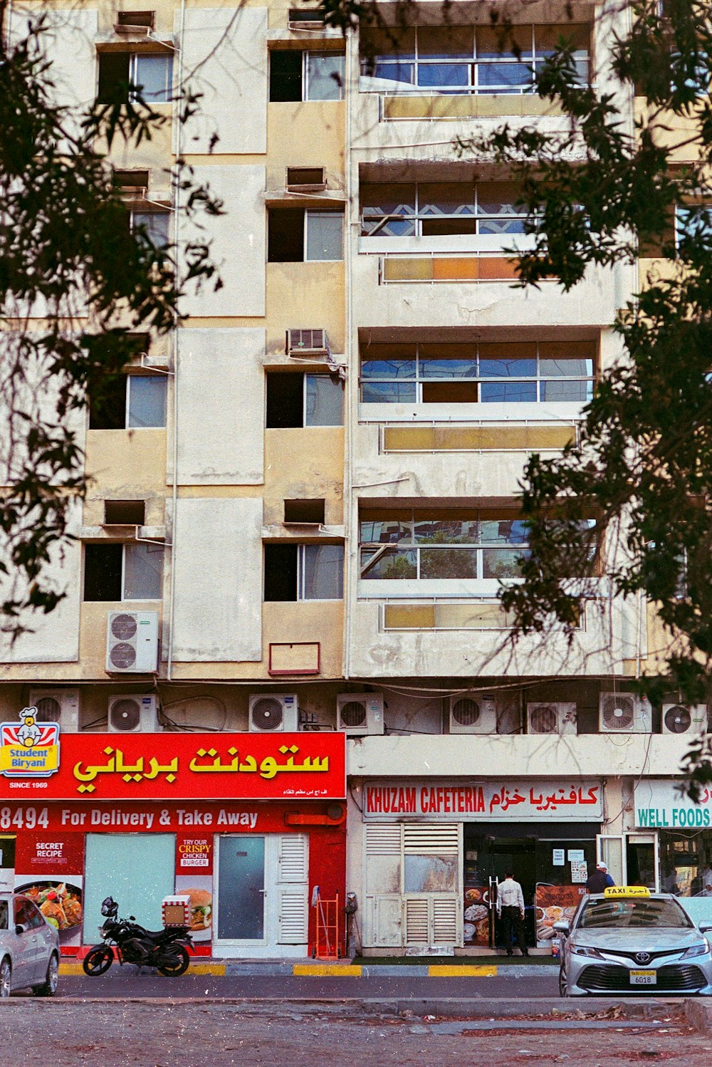 brown concrete building near green tree during daytime