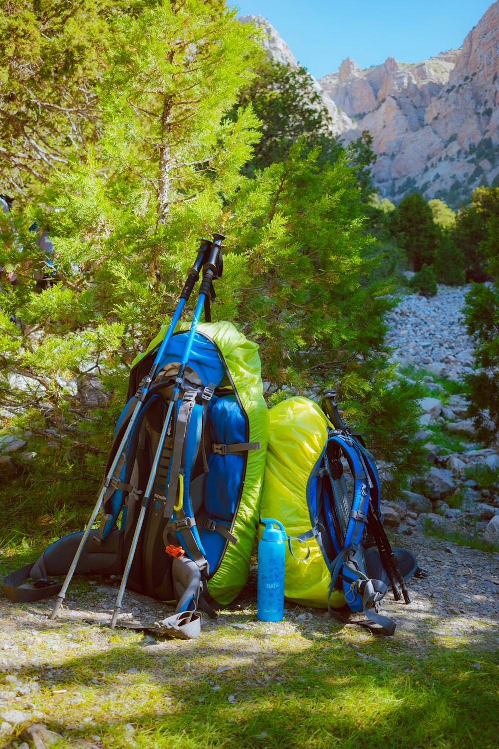 blue and black hiking backpacks on gray rocky ground