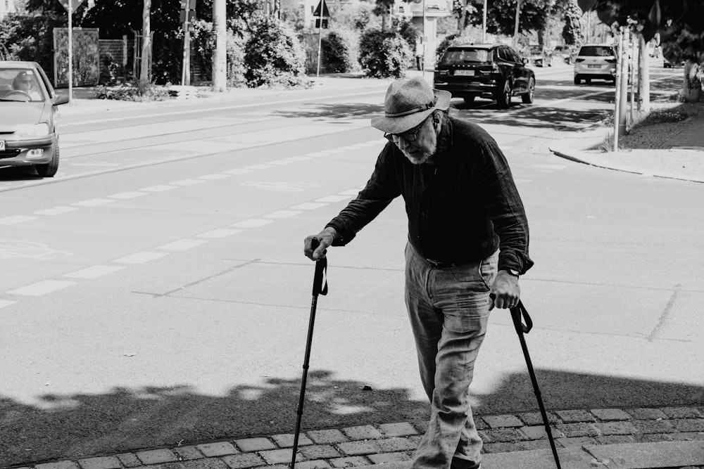 Hombre con chaqueta negra y pantalones blancos sosteniendo una patineta negra