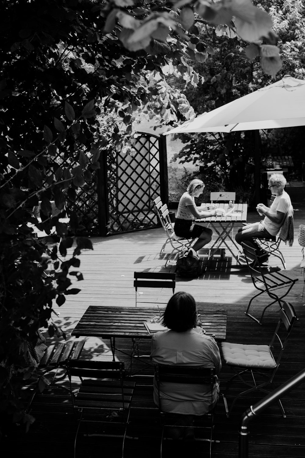 grayscale photo of people sitting on bench