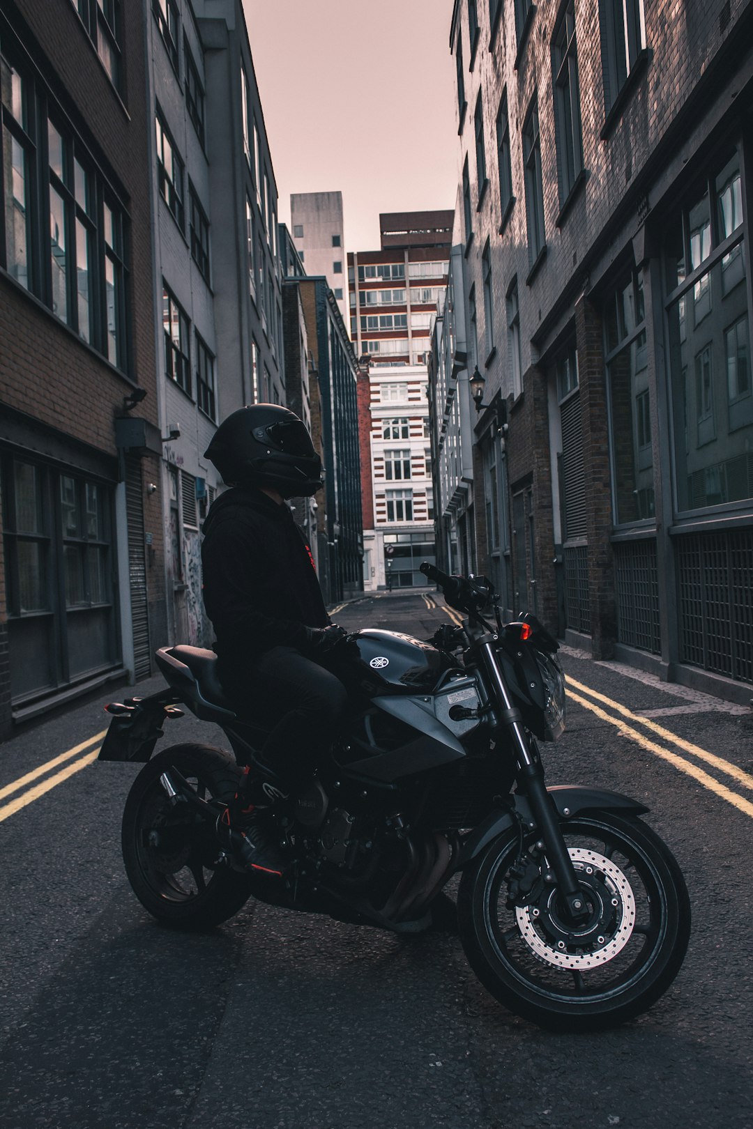 man in black jacket riding black motorcycle on road during daytime