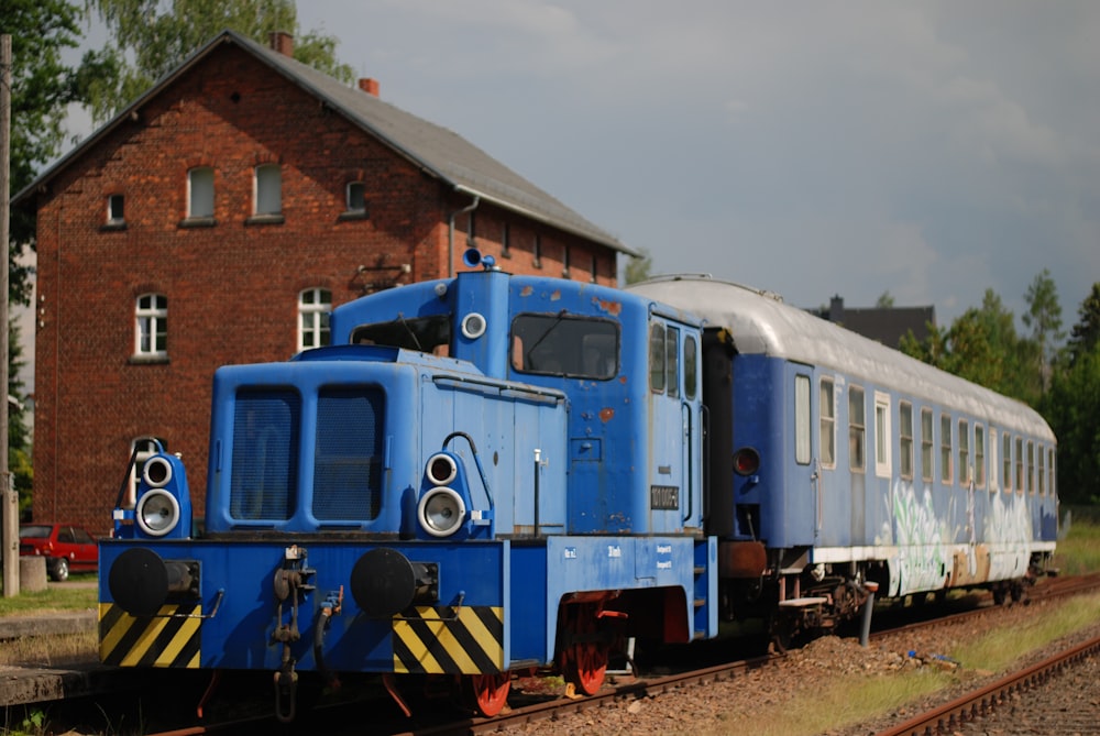 昼間の線路を走る青と白の列車