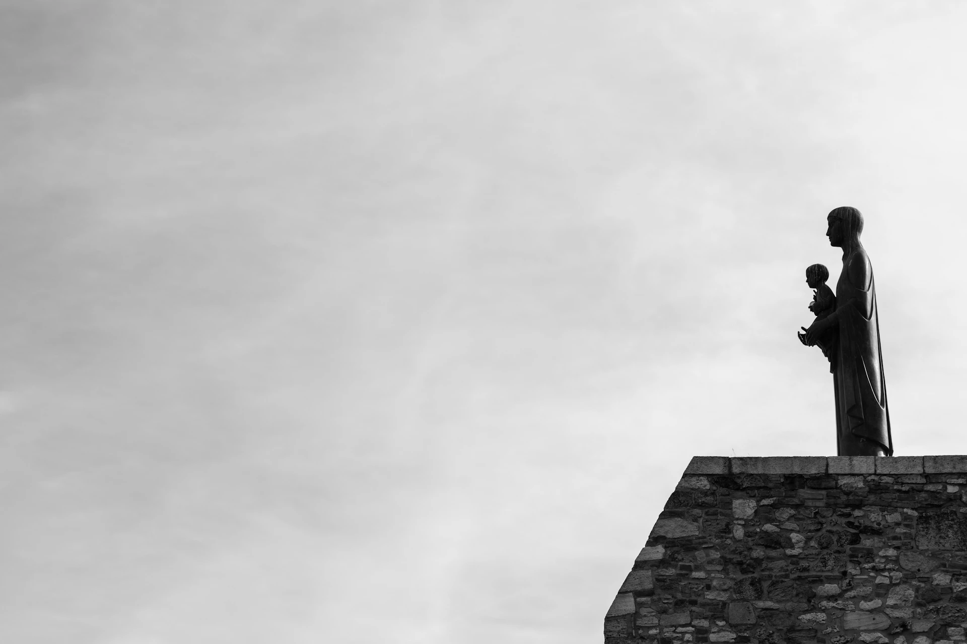 grayscale photo of concrete building under cloudy sky