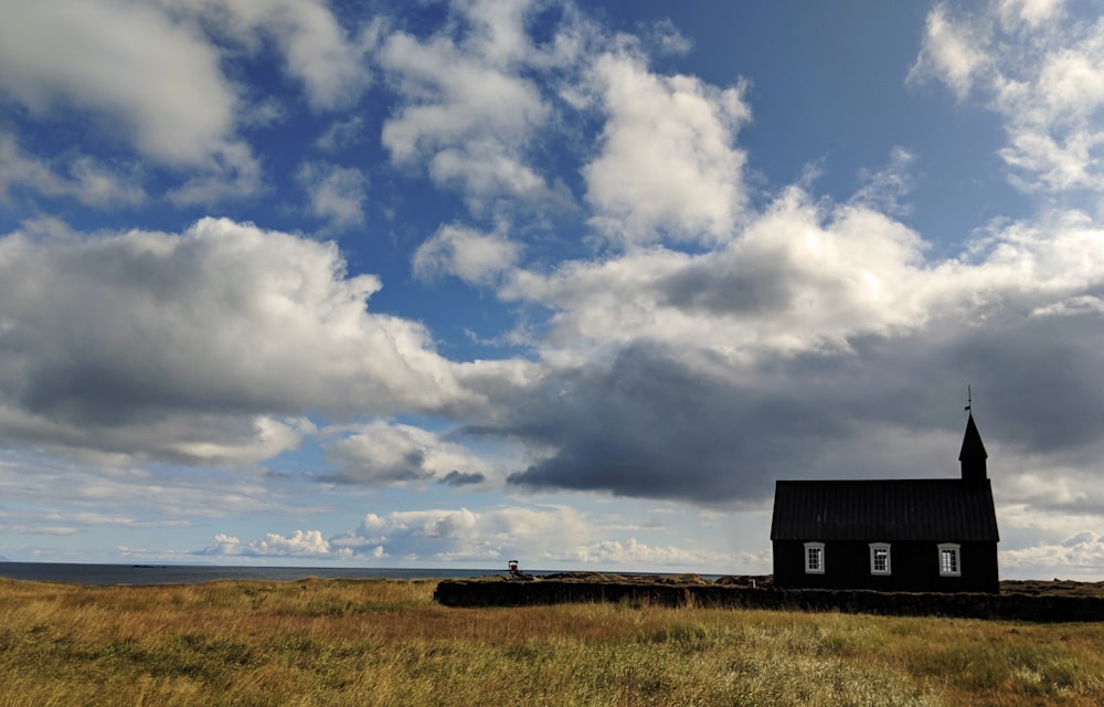 Casa blu e bianca sul campo di erba verde sotto nuvole bianche e cielo blu durante il giorno