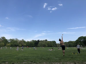 A vibrant scene of people enjoying various sports activities outdoors, with a clear sky and energetic atmosphere.