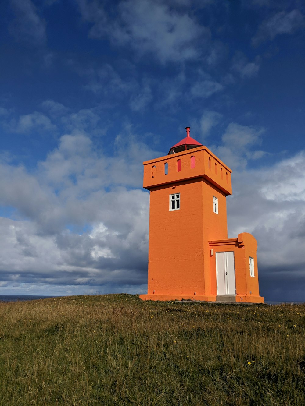 orange and white concrete building under cloudy sky during daytime