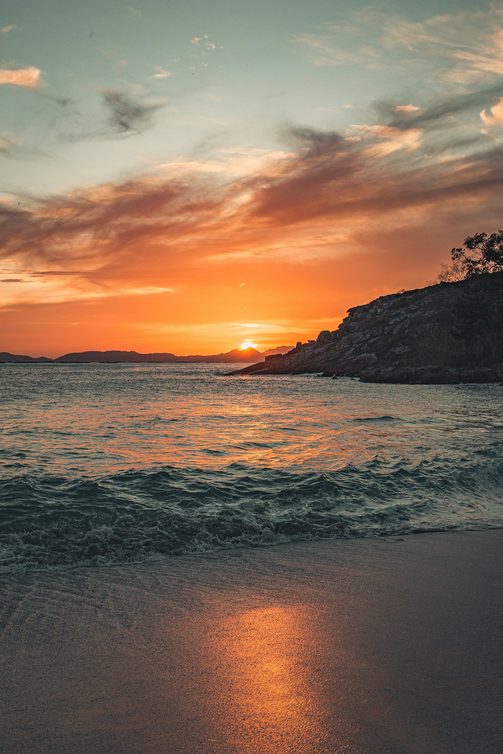 ocean waves crashing on shore during sunset