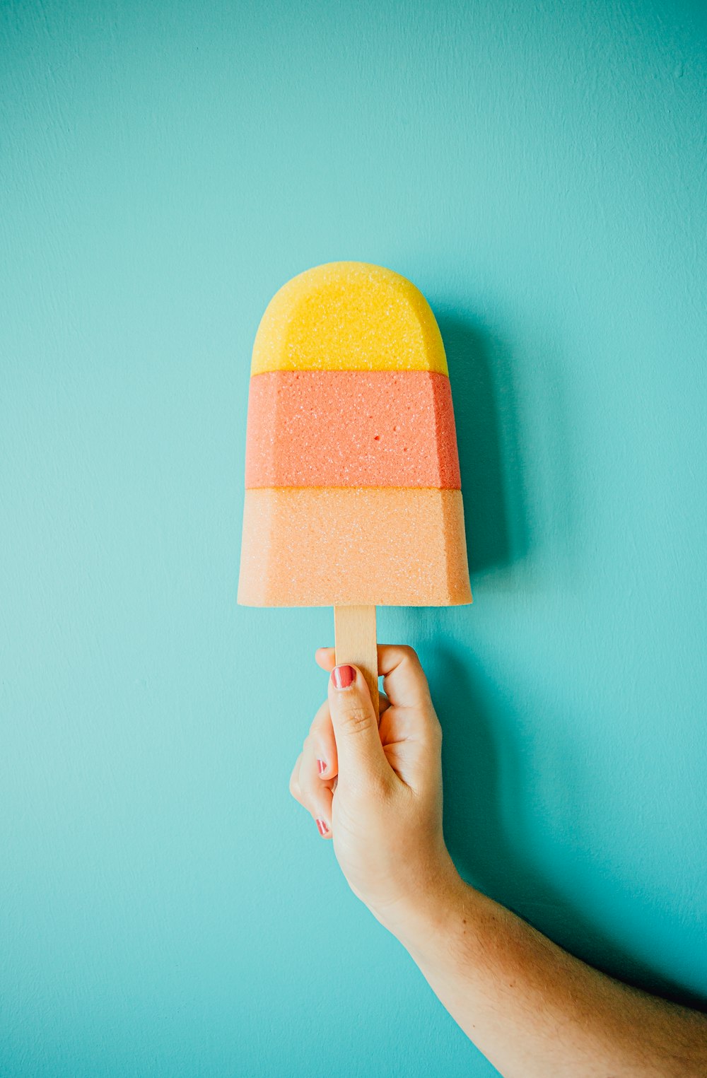 person holding yellow and brown ice cream cone