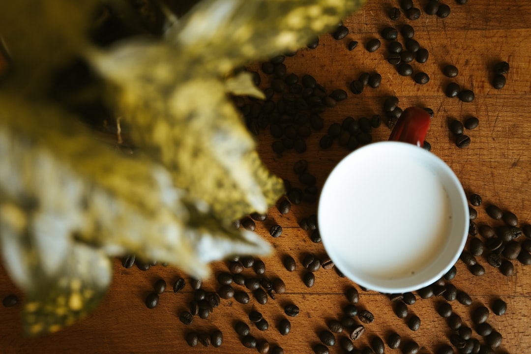 white ceramic mug on brown and black coffee beans