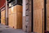 brown wooden door near gray concrete wall