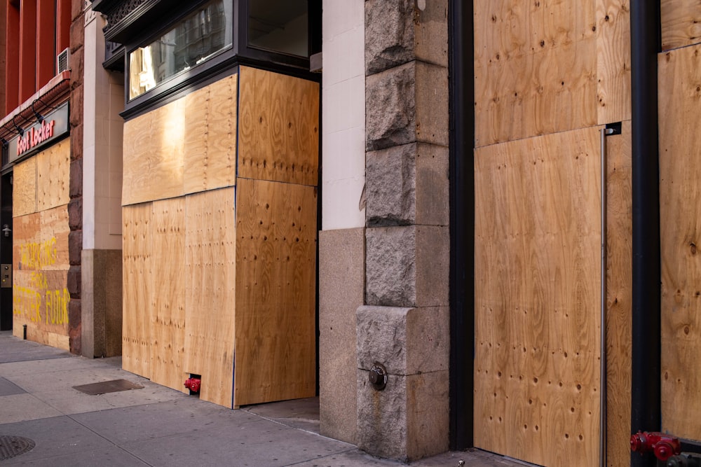 brown wooden door near gray concrete wall