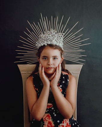 A soft pastel illustration of a little princess with a golden crown surrounded by sparkling stars and delicate flowers.