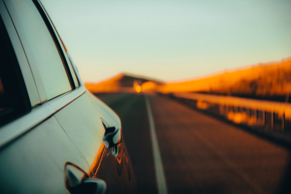 Auto nera sulla strada durante il tramonto