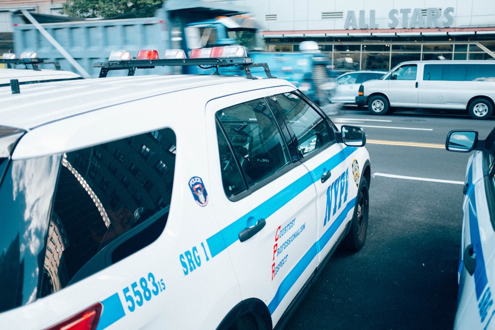 white and blue police car on road during daytime