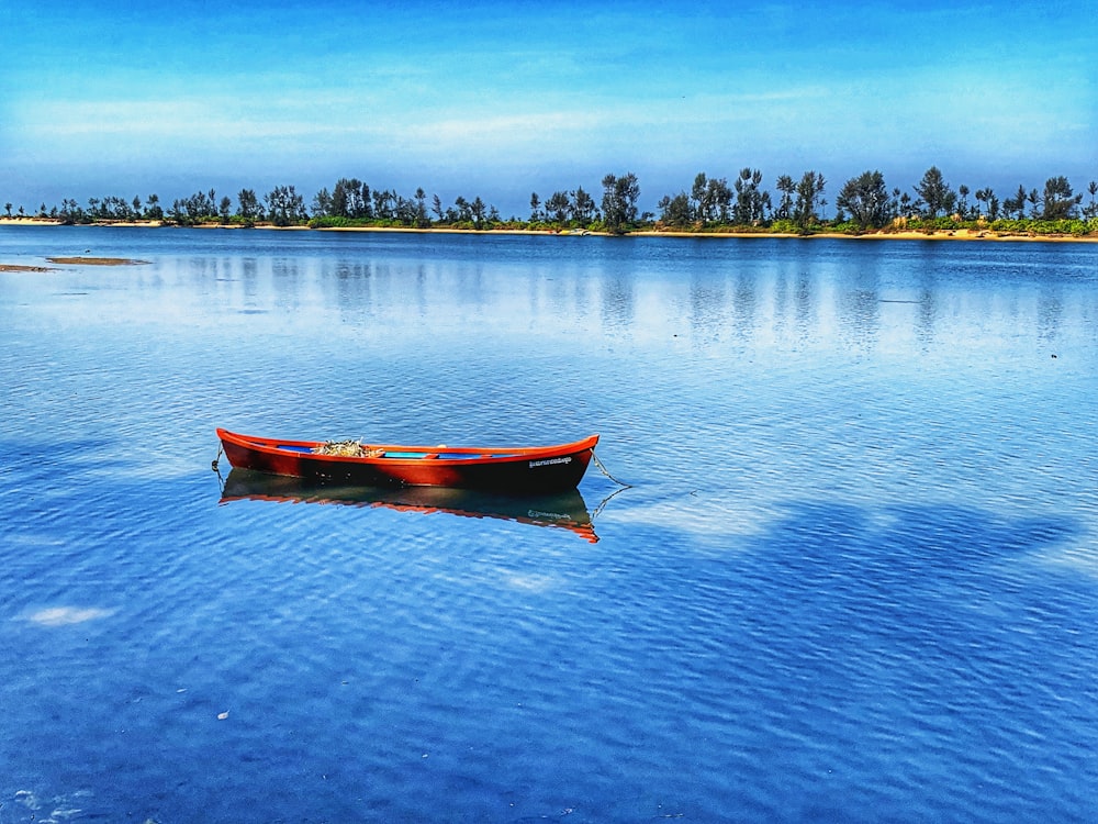 red and white boat on body of water during daytime