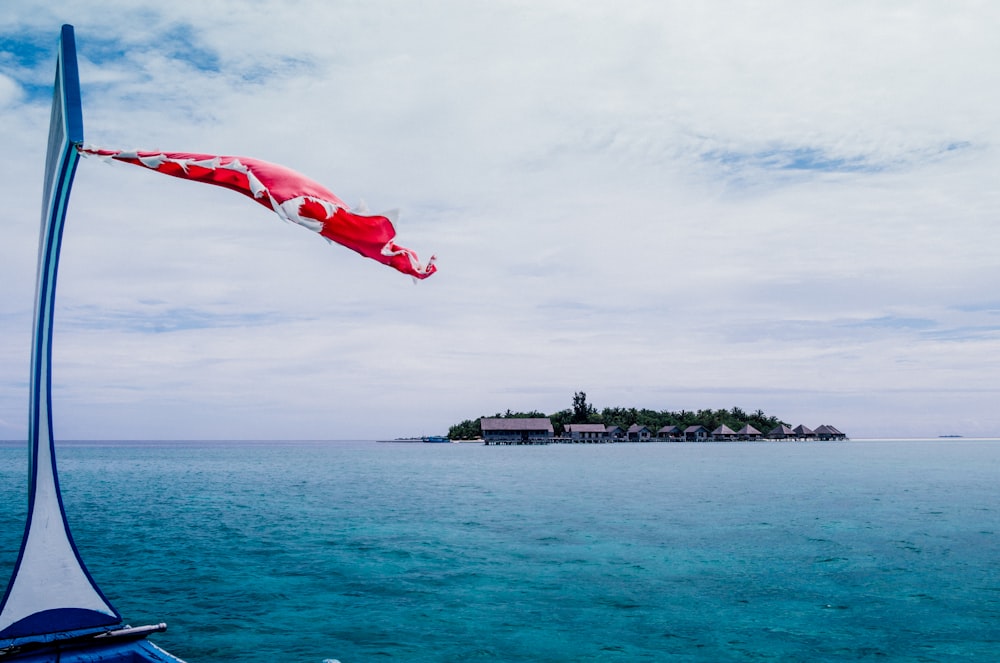 red flag on top of building near body of water during daytime