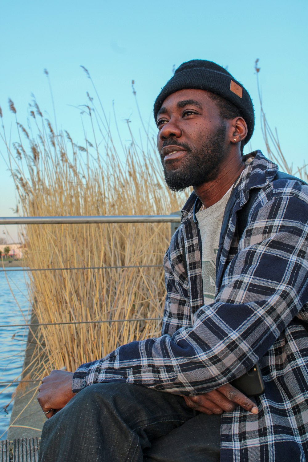 man in blue white and black plaid dress shirt wearing black cap