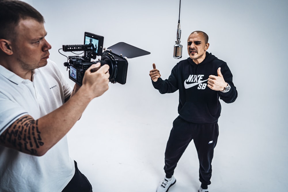 man in blue crew neck t-shirt holding black camera