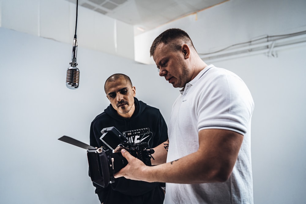 man in white crew neck t-shirt holding black microphone