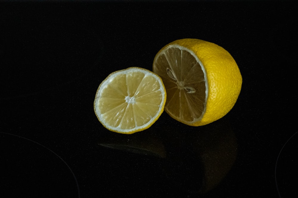 in Scheiben geschnittene Zitrone auf schwarzer Oberfläche